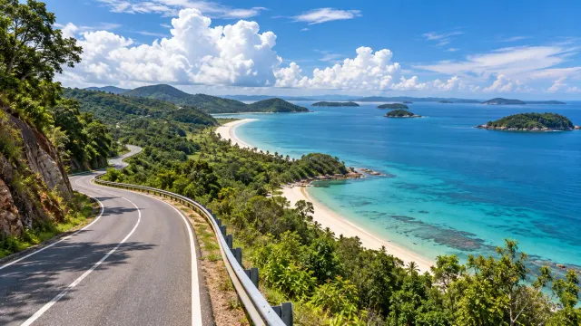 Illustration: winding coastal road above a sandy beach and turquoise sea