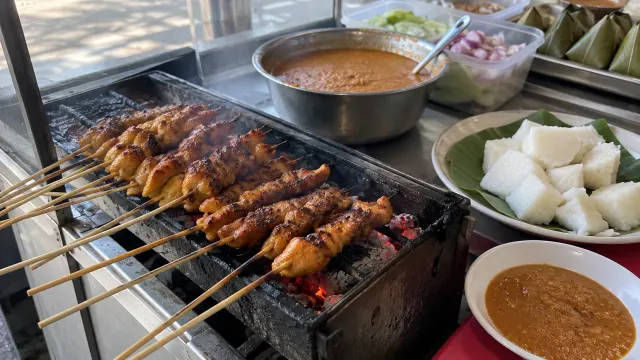 Illustration: chicken satay on a small grill