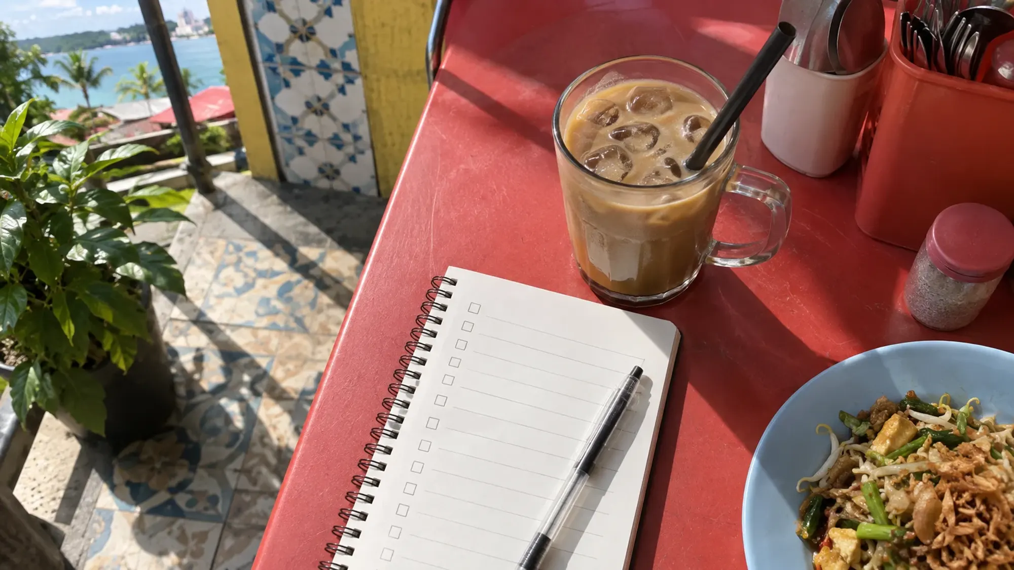 A notebook and checklist at a Batam hawker table