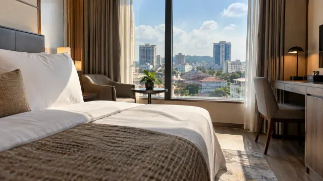 A neatly made guest room with a window view of a 3-star city hotel — Ando Hotel Batam, a 3-star city hotel in Nagoya, Batam