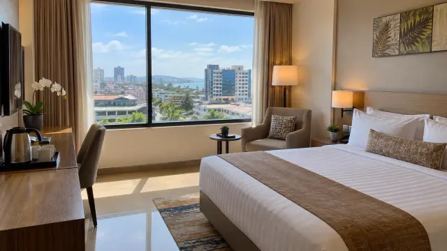 A neatly made guest room with a window view of a 3-star city hotel — Aston Inn Gideon Hotel Batam, a 3-star city hotel in Nagoya, Batam
