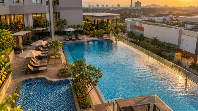The swimming pool area in late afternoon of a 4-star city hotel — Oakwood Hotel & Apartments Grand Batam, a 4-star city hotel in Nagoya, Batam